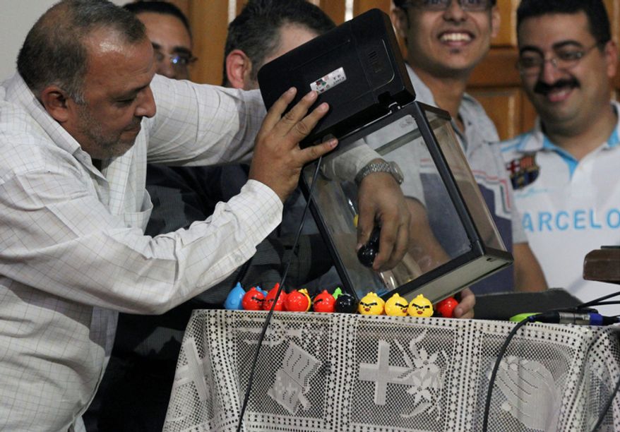 In this Saturday Nov. 3, 2012 photo, a plastic ball containing a name is drawn to determine which lucky boy will be selected to chose the new Coptic pope in a ceremony where the blindfolded boy will pull one of three names from a crystal chalice. Egypt's ancient Coptic Christian church named a new pope on Sunday, Nov. 4, 2012 to spiritually guide the community through a time when many fear for their future with the rise of Islamists to power and deterioration in police powers after last year's uprising. (Mohammed Abu Zeid)