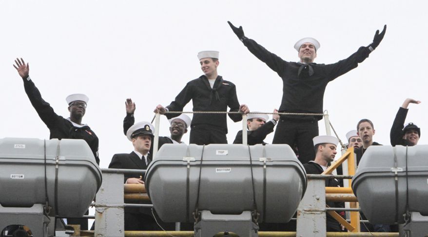Sailors on board react as the USS Enterprise returns to Norfolk Naval Station as the 51-year-old ship completes its 25th and final deployment. The Enterprise began shutting down its eight nuclear reactors almost as soon as it arrived at its pier, where thousands of cheering family members and friends welcomed the ship home from its 25th and final deployment after nearly eight months at sea. (AP Photo/The Virginian-Pilot, Steve Earley)