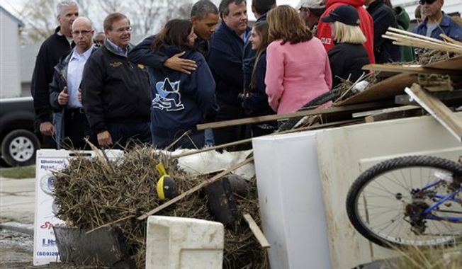 President Obama, center, and and Gov. Chris Christie meet with local residents as they tour neighborhood effected by superstorm Sandy, Wednesday, Oct. 31, 2012 in Brigantine, N.J. (AP Photo/Pablo Martinez Monsivais)