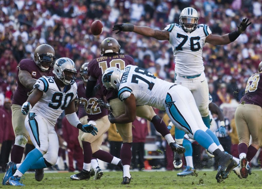 Washington Redskins quarterback Robert Griffin III (10) is hit hard in the fourth quarter by Carolina Panthers defensive tackle Nate Chandler (78), Landover, Md., Sunday, November 4, 2012. (Craig Bisacre/The Washington Times)
