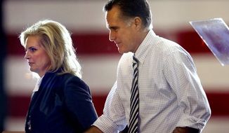 Former Massachusetts Gov. Mitt Romney (right), the Republican presidential candidate, steps offstage with his wife, Ann, after a speech at a campaign event at the International Exposition Center in Cleveland on Sunday, Nov. 4, 2012. (AP Photo/David Goldman)