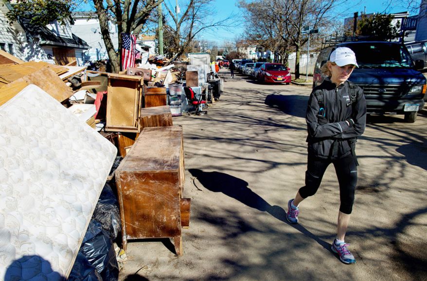 Mary Wittenberg, president of the New York Road Runners, reacts after viewing areas heavily damaged during Superstorm Sandy, in the Staten Island borough New York, Sunday, Nov. 4, 2012. With the cancellation of the New York Marathon, hundreds of runners, wearing their marathon shirts and backpacks full of supplies, took the ferry to hard-hit Staten Island and ran to hard-hit neighborhoods to help. (AP Photo/Craig Ruttle)