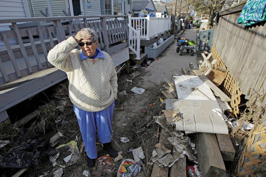 Ginny Flanagan, 70, who lives in Breezy Point, returns to her damaged home and destroyed neighborhood for the first time in the wake of Superstorm Sandy, Sunday, Nov. 4, 2012, in New York. (AP Photo/Kathy Willens)