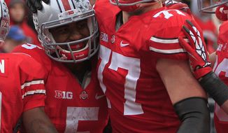 Ohio State quarterback Braxton Miller (left) celebrates his touchdown against Illinois with teammate Reid Fragel during the third quarter of Ohio State&#x27;s 52-22 win over Illinois on Nov. 3, 2012, in Columbus, Ohio. (Associated Press)