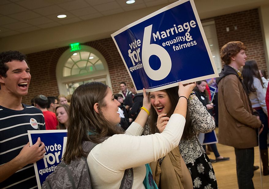 University of Maryland students Emma Murray, 19, (left) puts a Question 6 sign on the head of friend Megan Druss, 18, prior to the arrival of Maryland Governor Martin O'Malley (D) for a rally in support of Question 6, at the University of Maryland in College Park, Md., Monday, Nov. 5, 2012. (Rod Lamkey Jr./The Washington Times)