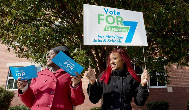Sisters Juasmine (left) and Jualece Huff campaign Tuesday outside of Winston Churchill High School in Potomac for Question 7, which would expand gambling in the state, because they think it will result in jobs and money for education. (Barbara L. Salisbury/The Washington Times)