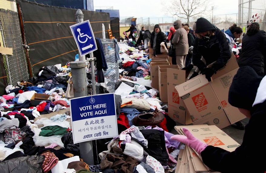 A sign directs would-be voters to a polling station in a school doubling as a donation site for assistance for victims of Superstorm Sandy in the Midland Beach section of Staten Island, N.Y. on Tuesday. Voting in the presidential election was the latest challenge for the hundreds of thousands of people in the New York-New Jersey area still affected by last week’s storm. (Associated Press)