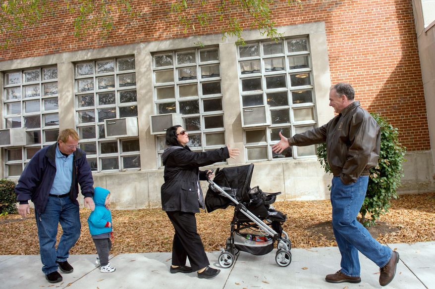 Michael and Laura Macario and their grandson Maxwell, 2, are greeted by Democratic candidate for Senate Tim Kaine, right, as they arrive to vote outside the polling entrance to G.W. Carver Elementary School on election day morning, Richmond, Va., Tuesday, November 6, 2012. (Andrew Harnik/The Washington Times)