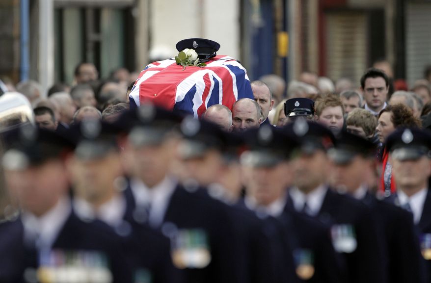 Prison officers carry the coffin of their slain colleague, David Black, to Molesworth Presbyterian Church in Cookstown, Northern Ireland, on Tuesday, Nov. 6, 2012. The father of two was shot dead by suspected paramilitary Irish Republican Army dissidents in County Armagh on Thursday as he drove to work at Maghaberry Prison. (AP Photo/Peter Morrison)