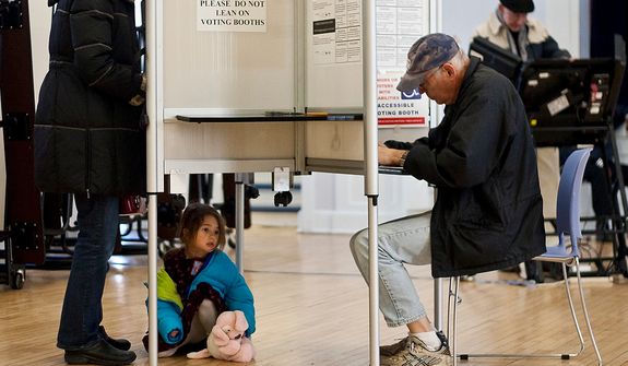 A child waits under the voting booth while her mom cast her vote at Janney Elementary School, precinct 30, Washington, D.C., Tuesday, Nov. 6, 2012 (Craig Bisacre/The Washington Times) ** FILE **