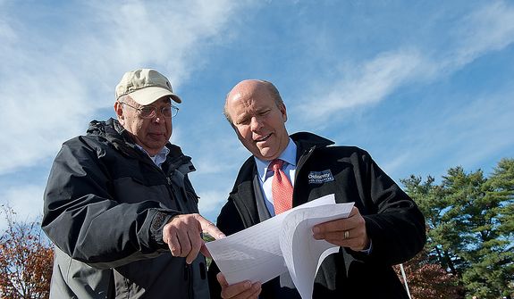 Jerry Garson (left) of the Ben Cardin campaign team, goes over data on Election Day with Maryland U.S. Congress hopeful John Delaney outside of Winston Churchill High School on Nov. 6, 2012. Delaney is hoping to oust Republican incumbent Roscoe Bartlett in the sixth district. (Barbara L. Salisbury/The Washington Times)