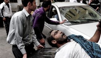 This photo released by the Syrian official news agency SANA, shows a Syrian man helping an injured man at the scene after a blast occurred according to footage and reports shown on State-run Al-Ikhbariya television in the Mazzeh al-Jabal district of the Syrian capital Damascus, Syria, Monday, Nov. 5, 2012. Several people were killed and injured, among them children, Al-Ikhbaria said. (AP Photo/SANA)