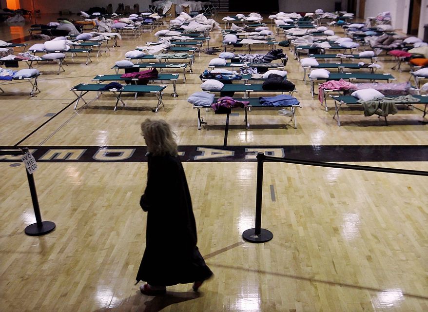 A voter walks through a makeshift shelter in a gymnasium at Toms River East High School on Tuesday, Nov. 6, 2012, on the way to the polls in Toms River, N.J. Voter turnout was heavy in several storm-ravaged Jersey shore towns, with many voters expressing relief and even elation at being able to vote at all, considering the devastation. (AP Photo/Mel Evans)