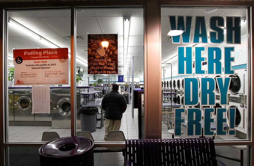 Matt Kamien waits to vote inside the 24-hour Su Nueva Laundromat in Chicago's 13th Ward on Election Day, Tuesday, Nov. 6, 2012. (AP Photo/Charles Rex Arbogast)