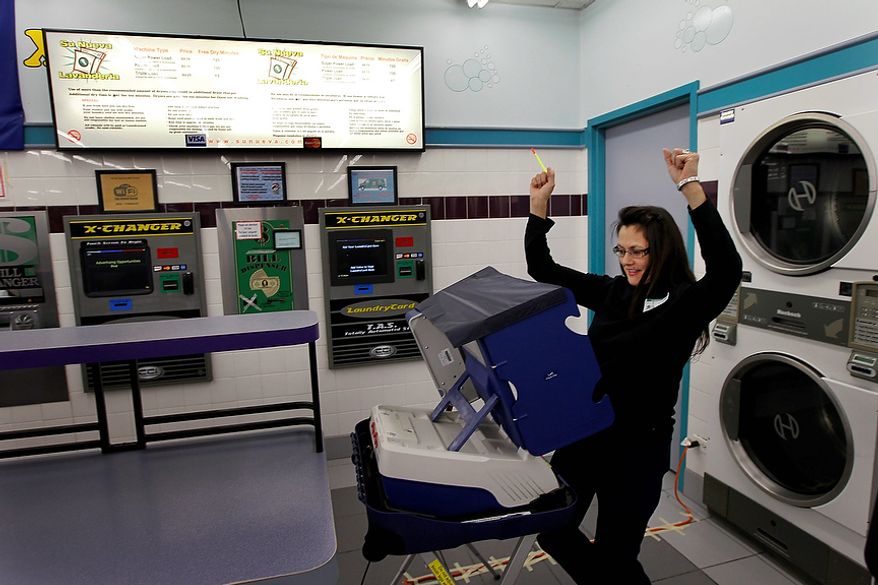 Leslie Fabian reacts after successfully voting electronically on Election Day at the 24-hour Su Nueva Laundromat in Chicago's 13th Ward on Tuesday, Nov. 6, 2012. (AP Photo/Charles Rex Arbogast)