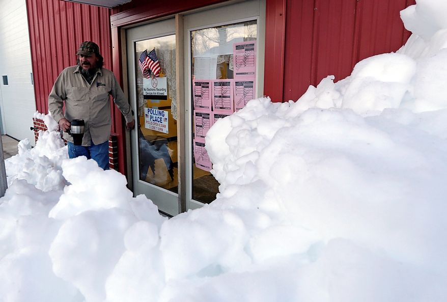 Snow surrounds the polling precinct in Terra Alta, W.Va., as Peter Hough heads to work after casting his ballot on Election Day, Tuesday, Nov. 6, 2012. (AP Photo/Dave Martin)