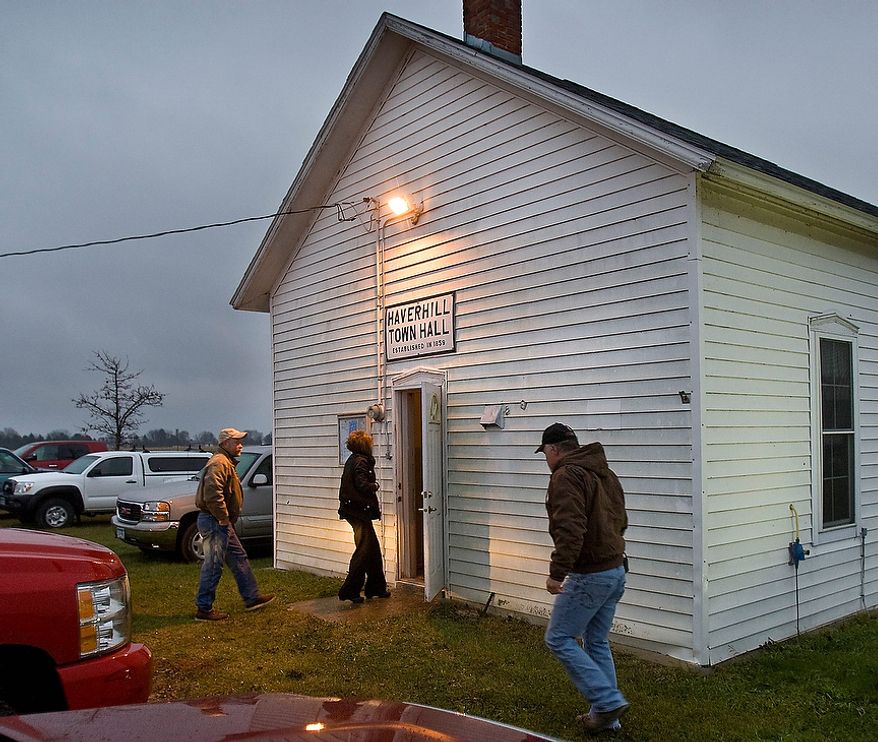 Early morning voters were not deterred by the cold rain Tuesday, Nov. 6, 2012, as they come to cast their ballots at Haverhill Town Hall, northeast of Rochester, Minn. Americans are heading to polling places across the country Tuesday. (AP Photo/The Rochester Post-Bulletin, Jerry Olson)