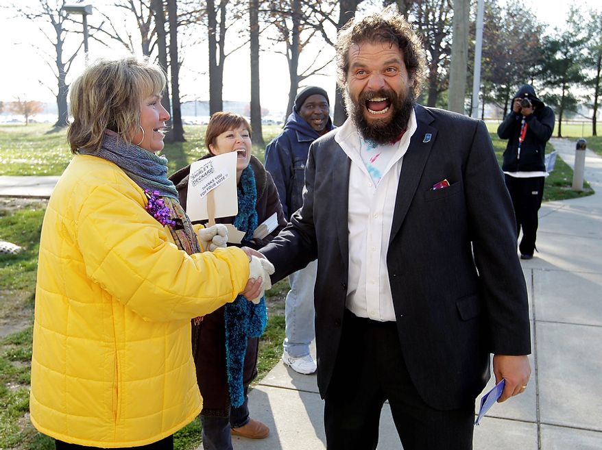 Indiana gubernatorial candidate Libertarian Rupert Boneham laughs as he's told by poling place volunteer Carol Mapier that he "has a great body" as he greeted voters outside a poling place in Indianapolis, Tuesday, Nov. 6, 2012. Boneham faces Democrat John Gregg and Republican Mike Pence in the gubernatorial race. Boneham was a contestant on the reality show Survivor. (AP Photo/Michael Conroy)