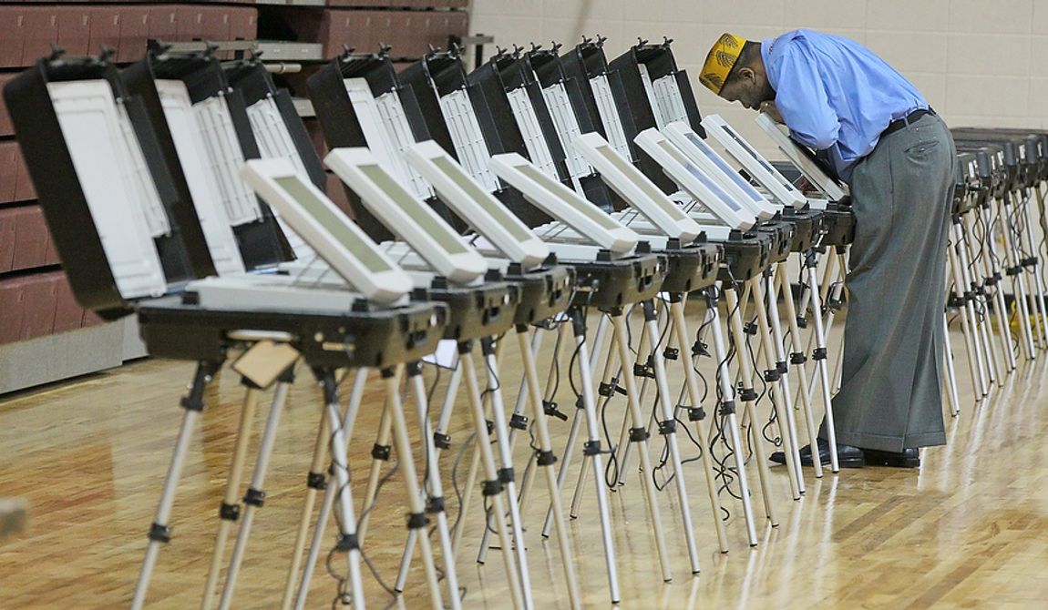 Poll Manager, Melvin Davis Jr. unlocks the voting machines  at Grady High School,  Tuesday, Nov. 6, 2012 in Atlanta. (AP Photo/Atlanta Journal-Constitution, John Spink)