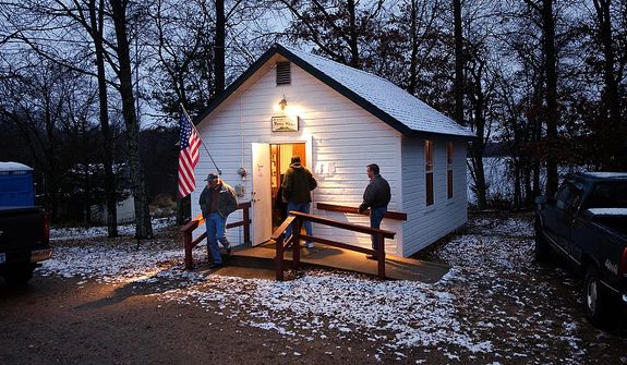 A light wet snow covers the roof and ground around the Jenkins Town Hall as early voters casts their ballots Tuesday, Nov. 6, 2012 in Jenkins, Minn. Jenkins is located in Crow Wing County in northern Minnesota. (AP Photo/Tom Olmscheid)
