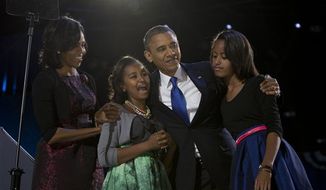 President Barack Obama, accompanied by first lady Michelle Obama and daughters Malia and Sasha arrive at the election night party Wednesday, Nov. 7, 2012, in Chicago. Obama defeated Republican challenger former Massachusetts Gov. Mitt Romney. (AP Photo/Carolyn Kaster)