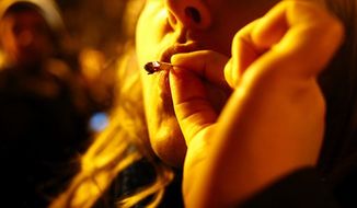 A 30-year-old woman smokes marijuana at a street party after I-502 was approved Tuesday, Nov. 6, 2012, in Seattle&#39;s Capitol Hill neighborhood. Initiative 502 decriminalizes the possession of up to an ounce of marijuana beginning Dec. 6. (AP Photo/The Seattle Times, Erika Schultz)