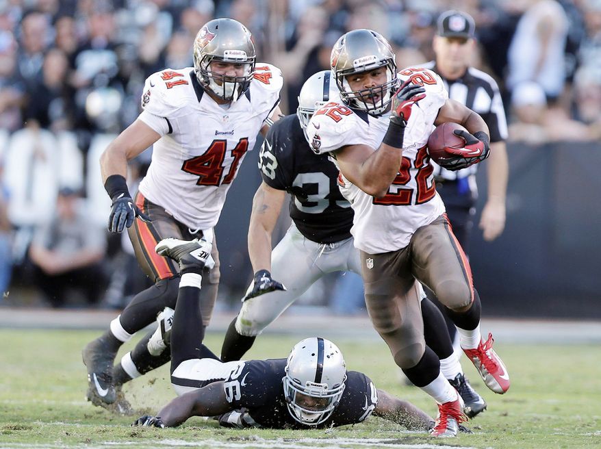 In this Nov. 4, 2012, file photo, Tampa Bay Buccaneers running back Doug Martin (22) runs for a 67-yard touchdown against the Oakland Raiders during the third quarter of an NFL football game in Oakland, Calif. Following a pair of dominating performances that not only thrust the rookie into the limelight, Martin has his team back on track. (AP Photo/Marcio Jose Sanchez, File)