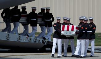 ** FILE ** Carry teams move transfer cases of the remains of the four Americans killed in Benghazi, Libya, from a transport plane during a ceremony Sept. 14, 2012, at Andrews Air Force Base, marking the start of congressional and State Department inquiries into the attack on the U.S. Consulate in Benghazi. (Associated Press)