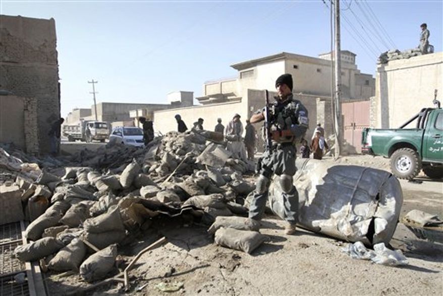An Afghan policeman stands guard at the scene of a suicide attack in Kandahar, south of Kabul, Afghanistan, Thursday, Nov. 8, 2012. Ahmad Jawed Faisal, a provincial governor spokesman, says a suicide bomber killed several policemen and wounded others in the southern city of Kandahar on Thursday. (AP Photo/Allauddin Khan)