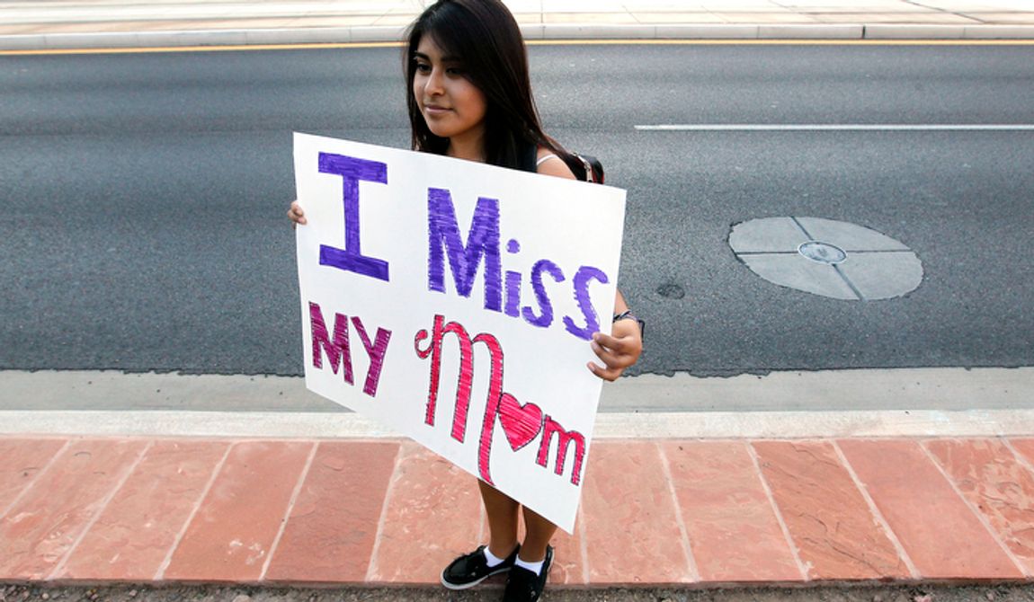 **FILE** Cynthia Diaz, 17, quietly holds up a sign Sept. 19, 2012, dedicated to her mother as she joins dozens who rally in front of U.S. Immigration and Customs Enforcement building, a day after a portion of Arizona&#x27;s immigration law took effect in Phoenix. Her mother was deported the previous year. Civil rights activists contend the state&#x27;s law will lead to systematic racial profiling, as the protesters chanted &quot;No papers, no fear.&quot; (Associated Press)