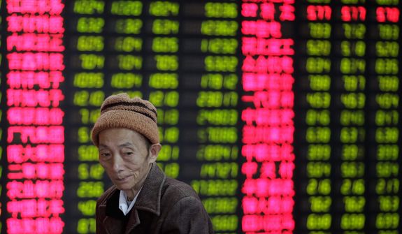An investor looks at the stock price monitor at a private securities company in Shanghai on Nov. 8, 2012. Asian stock markets tumbled after a ratings agency threatened to downgrade the U.S. if a solution to the so-called fiscal cliff isn&#39;t negotiated among lawmakers and newly re-elected President Obama. (Associated Press)