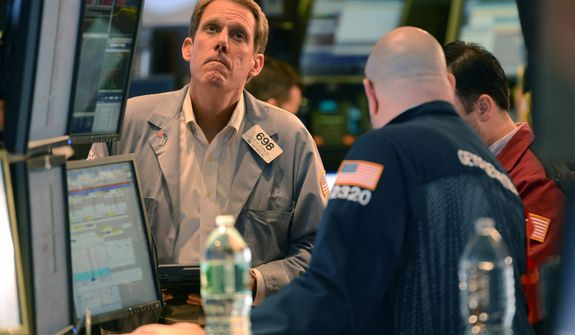 Luke Scanlon (left) of MND Partners Inc., works Nov. 7, 2012, on the floor of the New York Stock Exchange in New York. (Associated Press)
