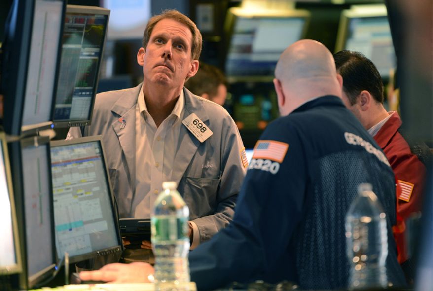 Luke Scanlon (left) of MND Partners Inc., works Nov. 7, 2012, on the floor of the New York Stock Exchange in New York. (Associated Press)