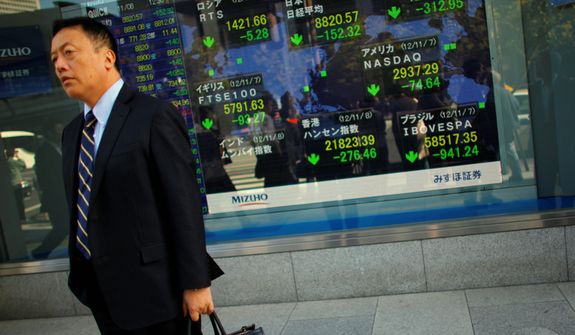 A man stands outside a securities firm in Tokyo on Nov. 8, 2012. Asian stock markets tumbled after a ratings agency threatened to downgrade the U.S. if a solution to the so-called fiscal cliff isn&#39;t negotiated among lawmakers and newly re-elected President Obama. (Associated Press)