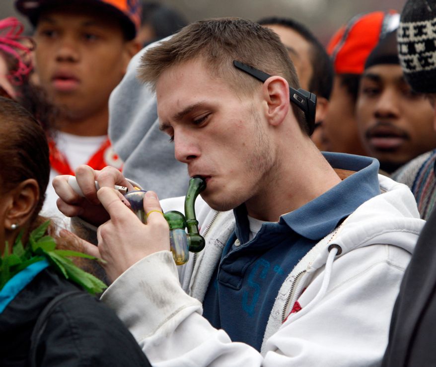 **FILE** An unidentified man lights up his pipe during a marijuana users rally at Civic Center Park across from the Capitol in Denver on April 20, 2010. Thousands of marijuana users gathered for the High Holiday, when pot users traditionally celebrate the drug, to urge Colorado to consider legalizing the drug for recreational use. (Associated Press)