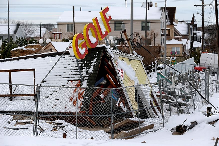 Superstorm Sandy debris from a miniature golf course sits under snow at Jenkinson's Boardwalk, Thursday, Nov. 8, 2012, in Point Pleasant, N.J. The area was hit by a nor'easter Wednesday the second storm in two weeks. (AP Photo/Julio Cortez)