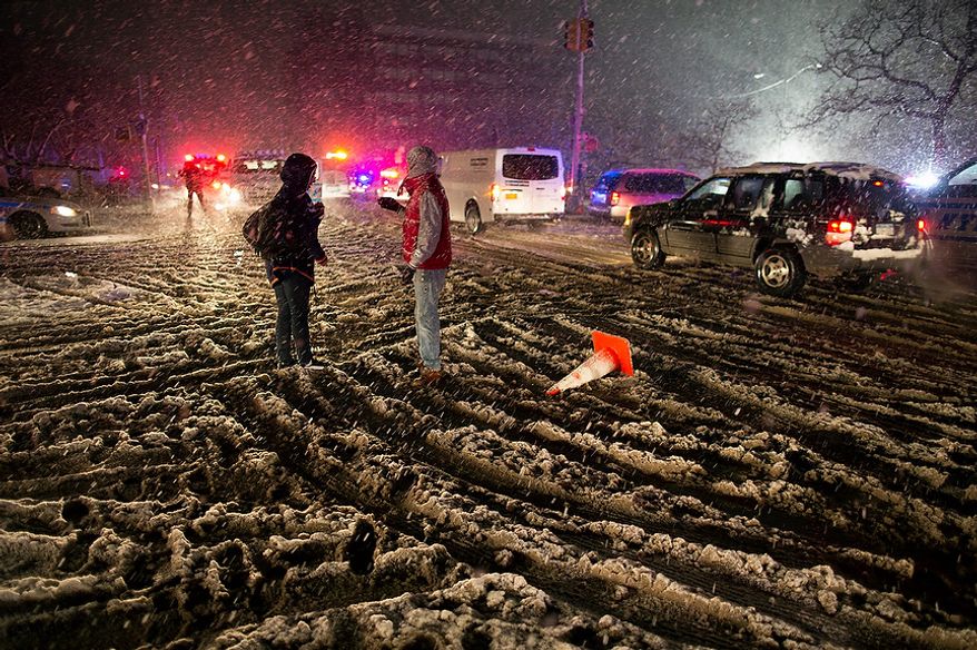 People walk through snow as it accumulates in the Rockaway Beach neighborhood of the borough of Queens, New York, Wednesday, Nov. 7, 2012, in the wake of Superstorm Sandy. A Noreaster is complicating an already difficult situation with wind and blowing snow. (AP Photo/Craig Ruttle)