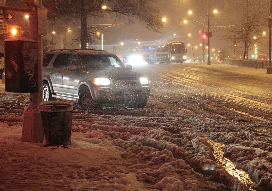 Cars navigate Queens Boulevard during a snow storm on Nov. 7, 2012, in the Queens borough of New York. Coastal residents of New York and New Jersey faced new warnings to evacuate their homes and airlines canceled hundreds of flights as the storm arrived only a week after Superstorm Sandy left dozens dead and millions without power. (Associated Press)
