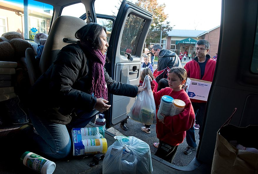 Soley Somma (left) of Wheaton, Md., a parishioner at St. Andrew the Apostle Catholic Church in Silver Spring, Md., loads donations into a passenger van Nov. 9, 2012. These items, along with clothes, toiletries and baby products, will be taken to St. Benedict Church in Holmdel, N.J., for victims of Hurricane Sandy. Somma, a former Brooklyn resident, says that she was so moved by the devastation that she saw on the news that she told her husband she was going to take a van and drive to New York. (Barbara L. Salisbury/The Washington Times)