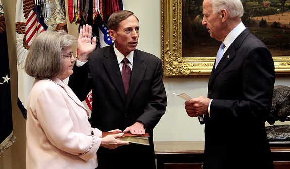 **FILE** Holly Knowlton Petraeus holds the family bible as her husband, David Petraeus, is sworn in by Vice President Joe Biden as CIA Director on Sept. 6, 2011, in the Roosevelt Room of the White House in Washington. (Associated Press)