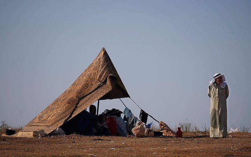 A Syrian family who fled from the violence in their village sits Nov. 5, 2012, in a tent at a displacement camp in the Syrian village of Atmeh, near the Turkish border. (Associated Press)