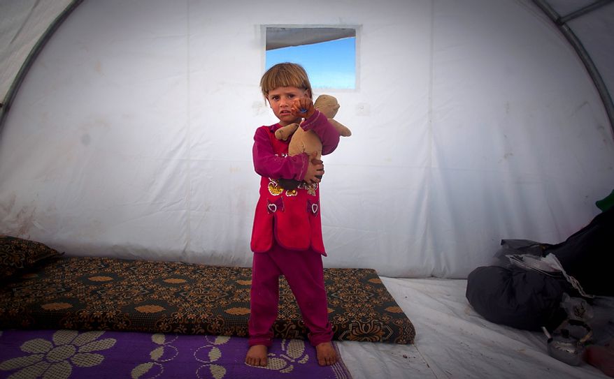 Amina Al Sado, 5, who fled with her family from the violence in their village, poses Nov. 7, 2012, for a photograph inside a tent at a displacement camp in the Syrian village of Atmeh, near the Turkish border. (Associated Press)