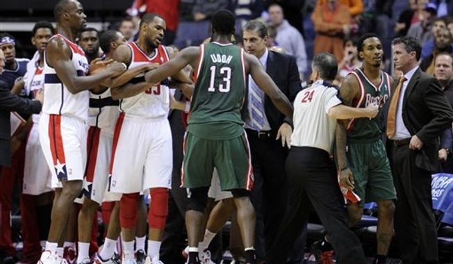 Milwaukee Bucks point guard Brandon Jennings, second from right, is restrained by referee Mike Callahan (24) as a scuffle breaks out against the Washington Wizards after a flagrant foul by Wizards guard Bradley Beal on Bucks guard Monta Ellis during the second half of an NBA basketball game on Friday, Nov. 9, 2012, in Washington. The Bucks won 101-91. (AP Photo/Nick Wass)