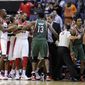 Milwaukee Bucks point guard Brandon Jennings, second from right, is restrained by referee Mike Callahan (24) as a scuffle breaks out against the Washington Wizards after a flagrant foul by Wizards guard Bradley Beal on Bucks guard Monta Ellis during the second half of an NBA basketball game on Friday, Nov. 9, 2012, in Washington. The Bucks won 101-91. (AP Photo/Nick Wass)
