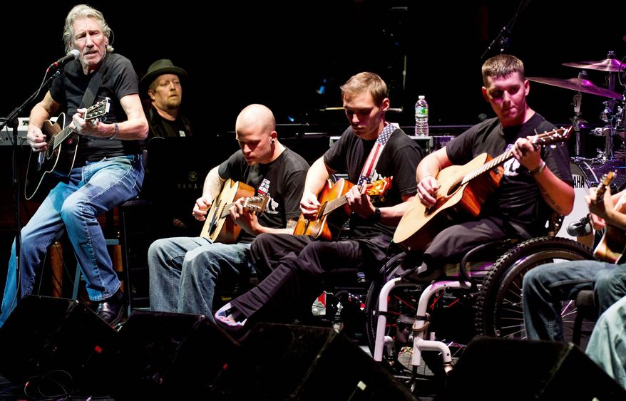 ** FILE ** In this Nov. 11, 2012, file photo, Roger Waters (left), formerly of Pink Floyd, performs with injured service members at the sixth annual Stand Up For Heroes benefit concert in New York. (Associated Press)