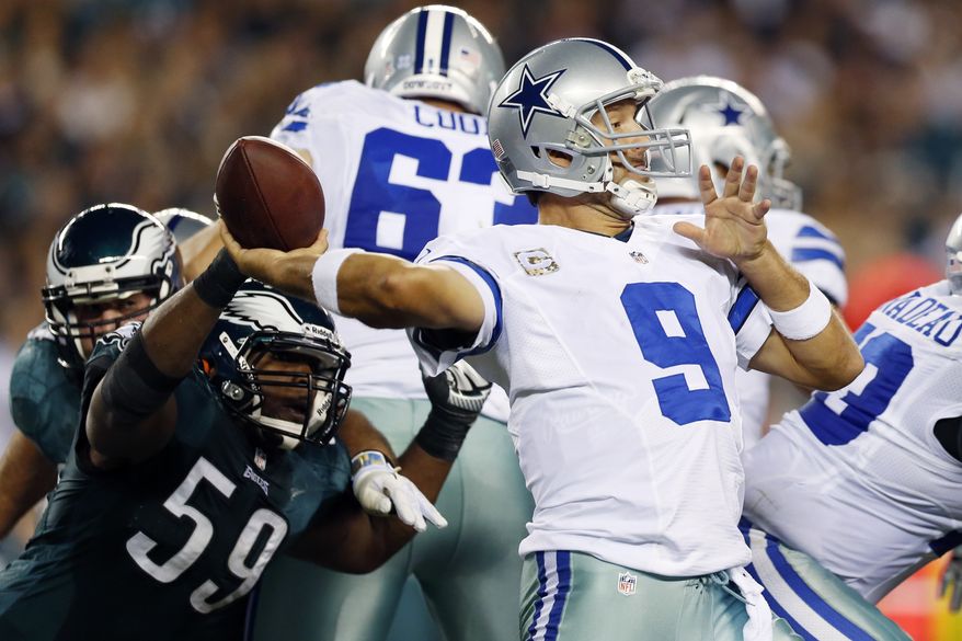 Dallas Cowboys quarterback Tony Romo, right, passes under pressure from Philadelphia Eagles middle linebacker DeMeco Ryans in the first half of an NFL football game, Sunday, Nov. 11, 2012, in Philadelphia. (AP Photo/Julio Cortez)