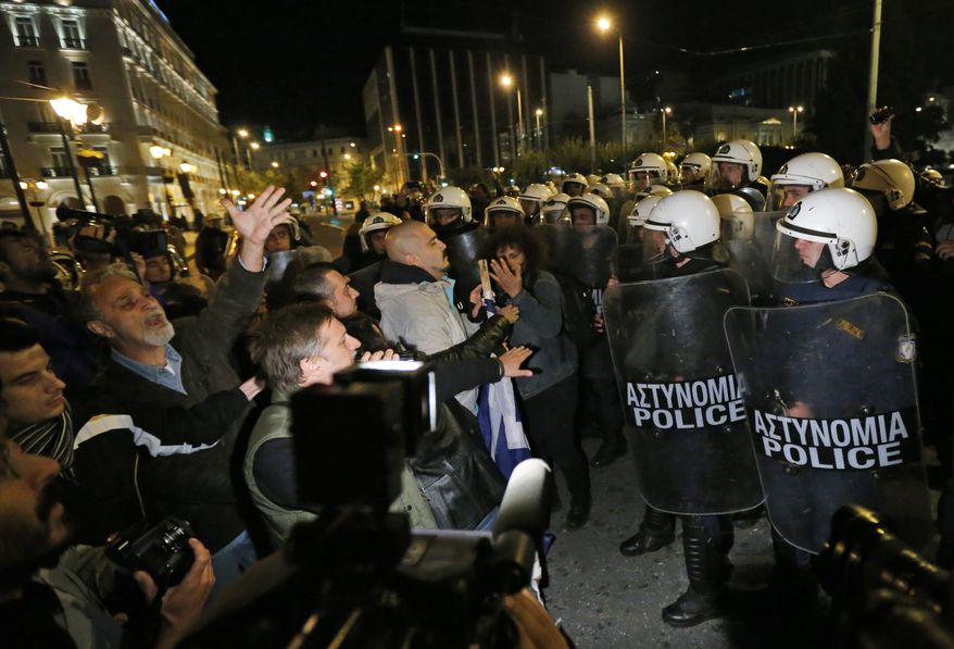 Greek riot police officers, right, push the last remaining protesters off the street, following an anti-austerity rally in front of the Parliament in central Athens, Sunday, Nov. 11, 2012. Thousands of protesters converged on the Greek capital's main square outside the Parliament on Sunday evening, as lawmakers debated the 2013 budget, which includes pension and salary cuts demanded by the country's international creditors in order for them to approve the next vital batch of rescue loans. (AP Photo/Lefteris Pitarakis)