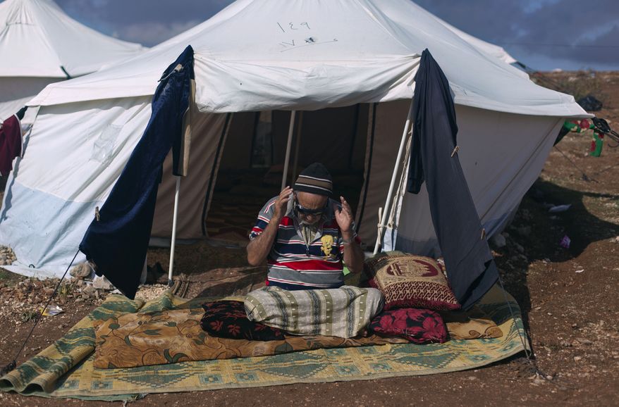 An elderly and disabled Syrian man who fled from the violence in his village prays Nov. 10, 2012, in front of his tent at a displaced persons camp in the Syrian village of Atma, near the Turkish border. (Associated Press)