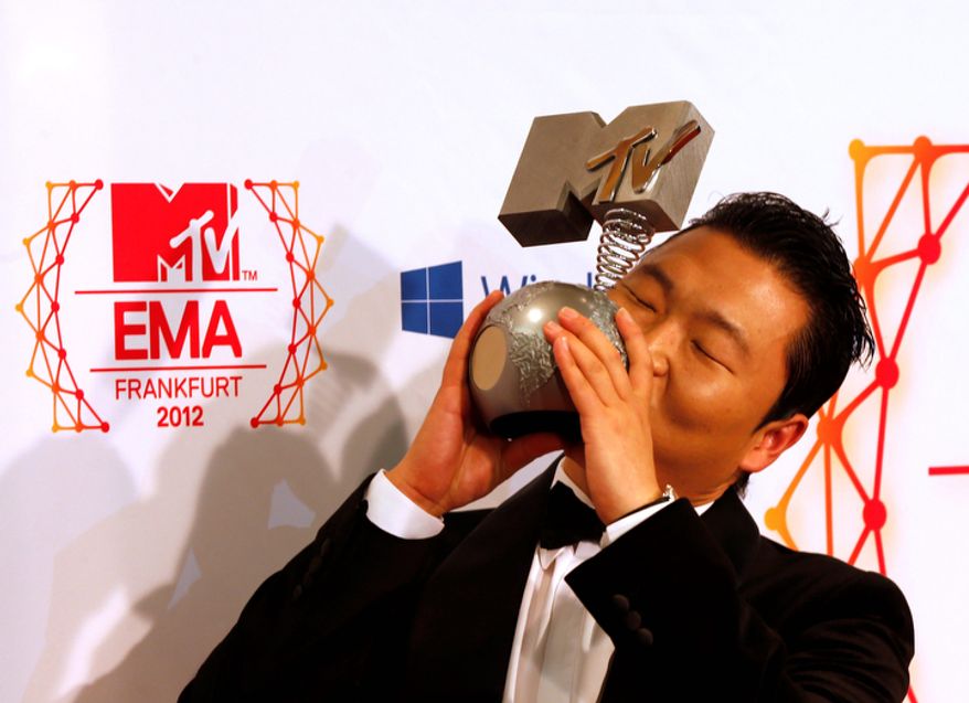 South Korean Psy presents his award for the best video during the 2012 MTV European Music Awards show at the Festhalle in Frankfurt, central Germany, Sunday, Nov. 11, 2012. (AP Photo/Frank Augstein)