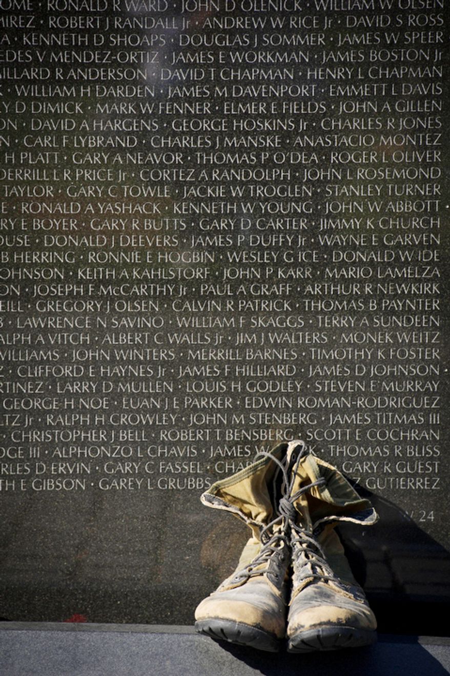 A pair of combat boots lat the the foot of one of the wall panels of names at the Vietnam Veterans Memorial during Veteran's Day weekend. (Rod Lamkey Jr./The Washington Times)